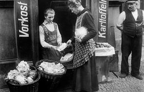 A woman takes a basket of banknotes to buy cabbage at a market during the 1933 hyperinflation in Weimar Germany.
