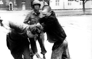  After American soldiers liberated Dachau in 1945, an inmate of the camp attacks a German soldier.