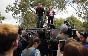 Organizers Cameron Kasky, left, and Jackie Corin, student survivors from Marjory Stoneman Douglas High School address fellow students before boarding buses in Parkland, Fla., Tuesday, Feb. 20, 2018, to rally outside the state capitol.   The students plan to hold a rally Wednesday in hopes that it will put pressure on the state's Republican-controlled Legislature to consider a sweeping package of gun-control laws, something some GOP lawmakers said Monday they would consider.