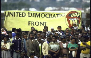 A group of mourners carry a United Democratic Front Banner during a mass funeral.