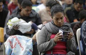 Venezuelan citizens wait to receive their temporary residence status at the immigration office in Lima, Peru.