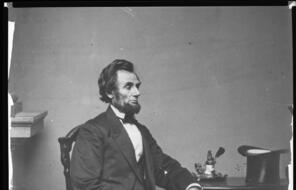 A full-length portrait of Abraham Lincoln, seated. 