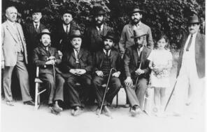 Group photo of men in suits and a young girl