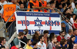 Fans in a soccer stadium with a banner depicting a star of David and words "Yid Army."