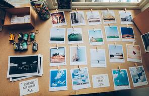 Assorted images of the outdoors organized in a grid on a beige wooden table.