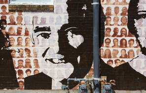 A black and white featured painting of John T. Fisher II on the Memphis Upstanders Mural, a painting on a brick wall in Memphis, TN.