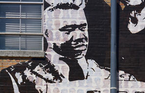 A black and white painting of T.O. Jones on the Memphis Upstanders Mural, a painting on a brick wall in Memphis, TN.