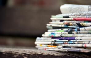 A colorful pile of newspapers on a table.