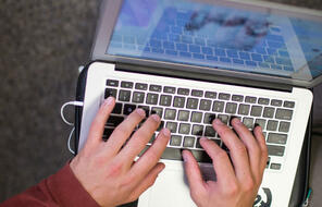 Picture of hand typing on laptop.