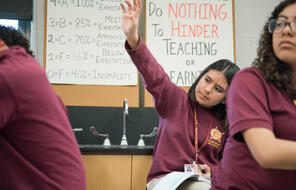 Female students raises her hand. 