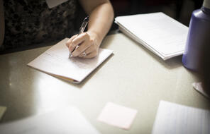 Woman writing on notebook paper