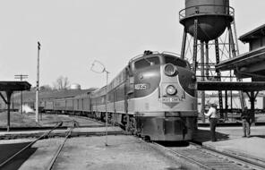 Southbound Illinois Central Railroad "Seminole" passenger train crosses main line of West Point Route at station in Opelika, Alabama in August 1955. Absence of interlocker required crew member to flag crossing.