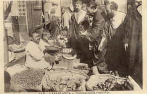 A large group of traders at a market with vegetables.