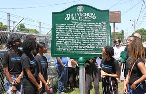 Photograph of students in front of the memorial marker for Eli Persons.