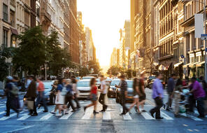 Pedestrians cross a busy city street