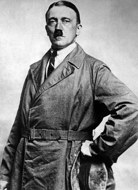 Portrait of Adolf Hitler in a brown trenchcoat, shirt, and tie.