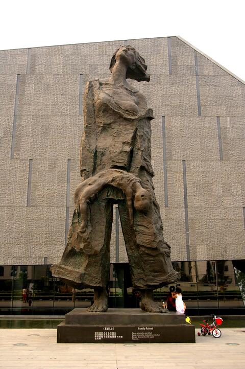  A monument of a woman holding a child stands at the front of the Nanjing Massacre Memorial Hall.