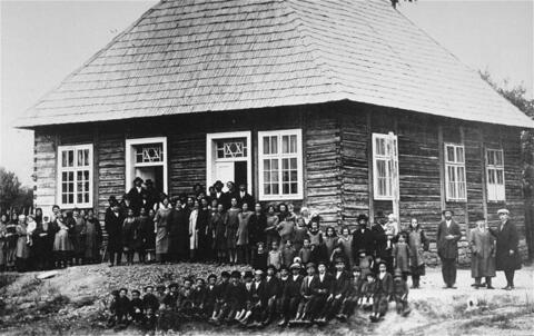 Group portrait outside of a wooden synagogue