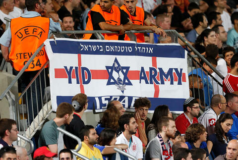 Fans in a soccer stadium with a banner depicting a star of David and words "Yid Army."