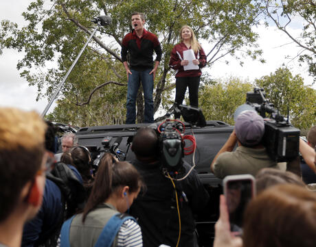 Organizers Cameron Kasky, left, and Jackie Corin, student survivors from Marjory Stoneman Douglas High School address fellow students before boarding buses in Parkland, Fla., Tuesday, Feb. 20, 2018, to rally outside the state capitol.   The students plan to hold a rally Wednesday in hopes that it will put pressure on the state's Republican-controlled Legislature to consider a sweeping package of gun-control laws, something some GOP lawmakers said Monday they would consider.