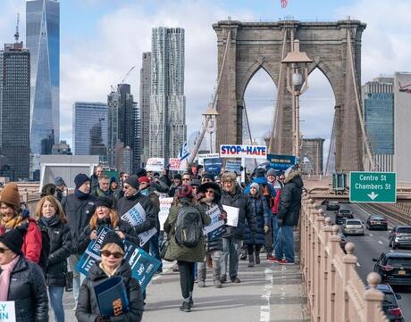 Photo antisemitism protesters marching over bridge.