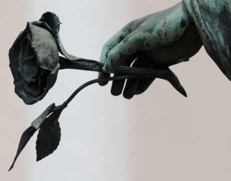 Zoomed in statue hand holding rose.