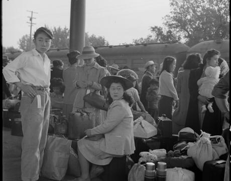  Families of Japanese ancestry awaiting the arrival of a train that will take them to Merced detention center, during the internment of Japanese Americans during World War II