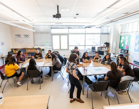 A birds eye view of a classroom filled with students in conversation.