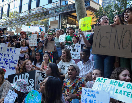 Image of young people holding protest signs as part of a protest for action on climate change