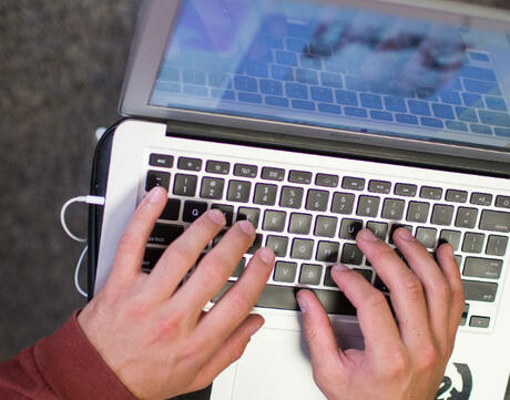 Picture of hand typing on laptop.