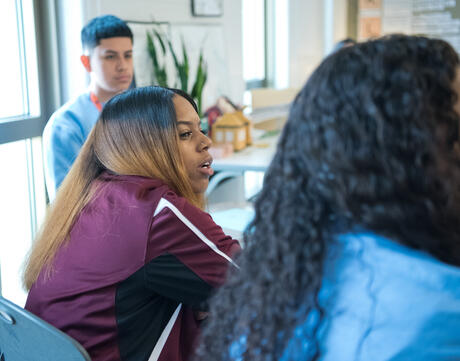 Female students engage in classroom discussion.