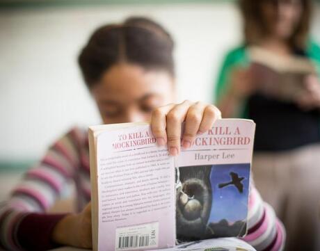 Picture of student holding up a book.