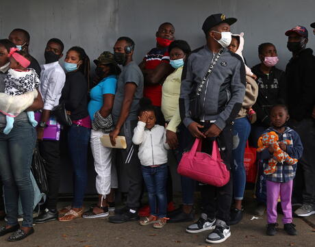 A group of adult and children migrants from Haiti stand in line to regularize their migratory situation.