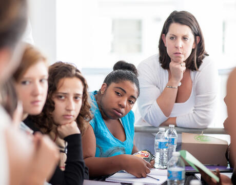 Photo of teacher overseeing a student discussion.