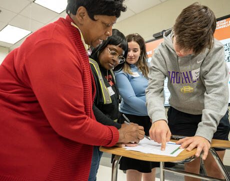 Students and educator work on an assignment