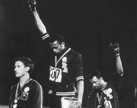 American track and field athletes Tommie Smith (C) and John Carlos (R), first and third place winners in the 200 meter race, protest with the Black Power salute as they stand on the winner's podium at the Summer Olympic games, Mexico City, Mexico, October 19, 1968. Australian silver medalist Peter Norman stands by.