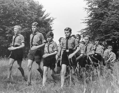A group of Hitler Youth marching through a field