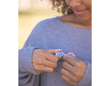 Young Woman Affixing a Vote Button on Her Shirt